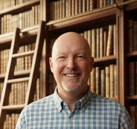 photo of a man with a background of a bookshelf